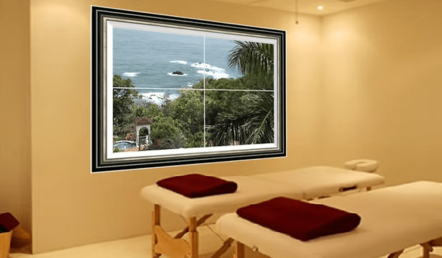 A Serene Massage Room Featuring Two Tables and a Large Window With a View of the Ocean.